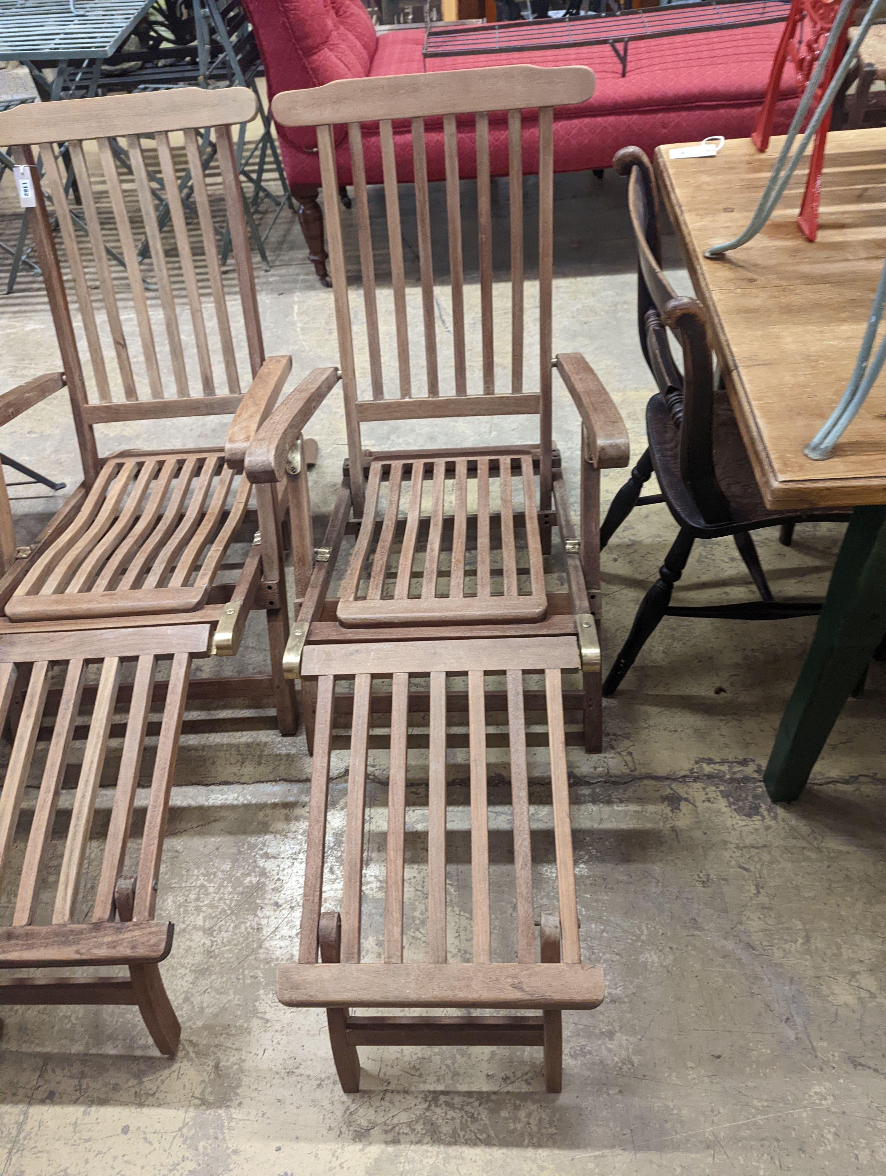 A pair of brass mounted teak garden steamer chairs, length 140cm, depth 58cm